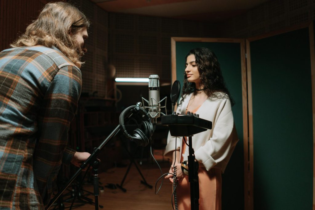 Eine Frau nimmt Gesang in einem professionellen Musikstudio auf.